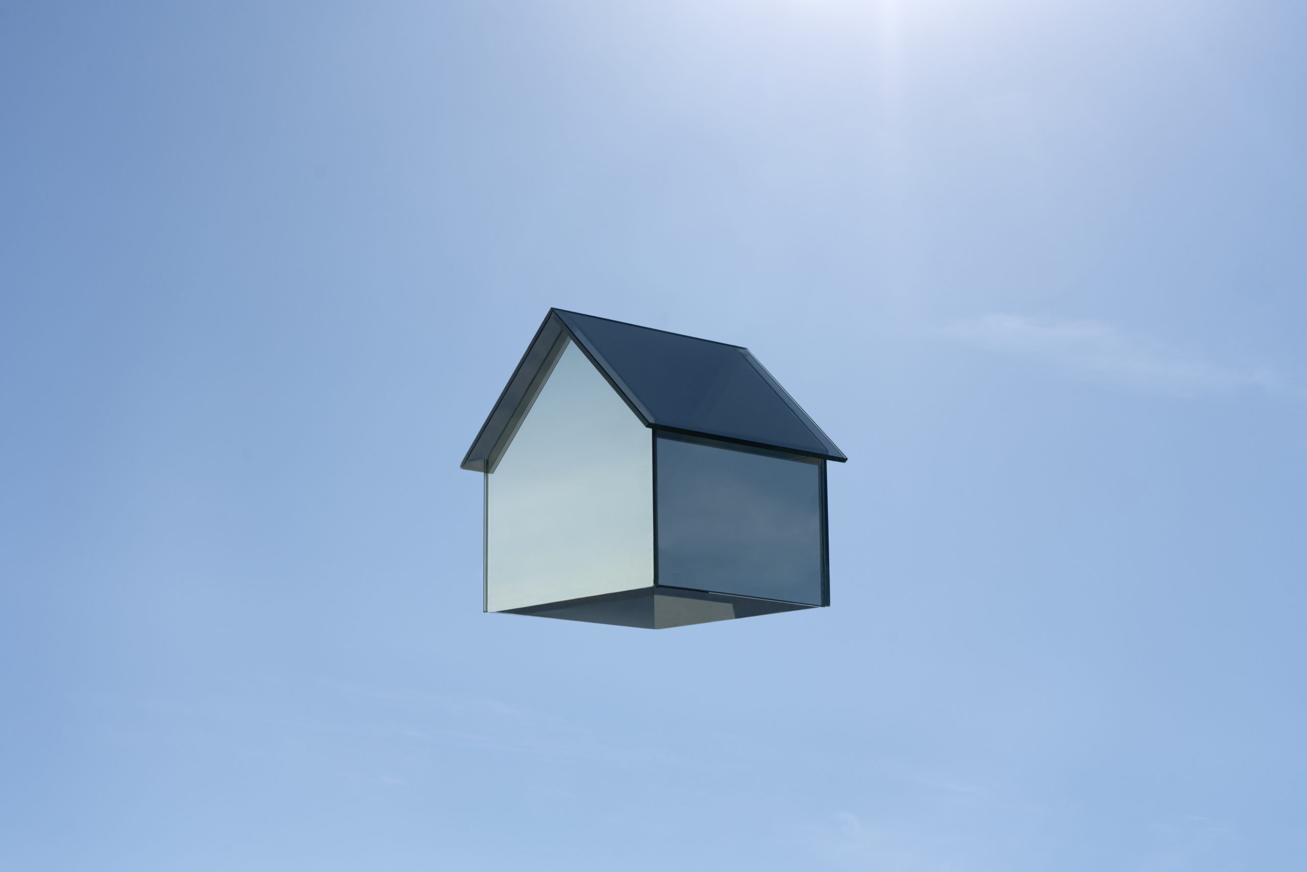 Levitating house made of glass symbolising the dream of owning a home