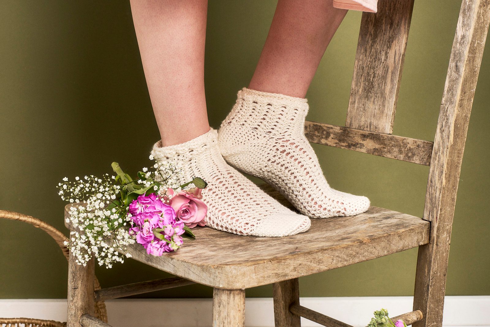 Cream-coloured lacy socks worn by a person standing on a chair