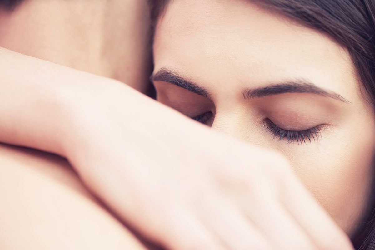 A close-up of a man and woman hugging