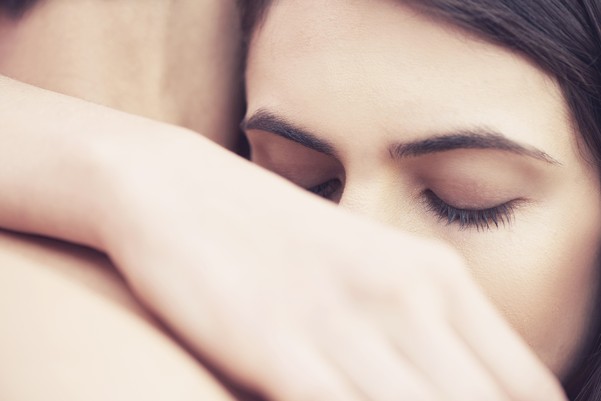 A close-up of a man and woman hugging