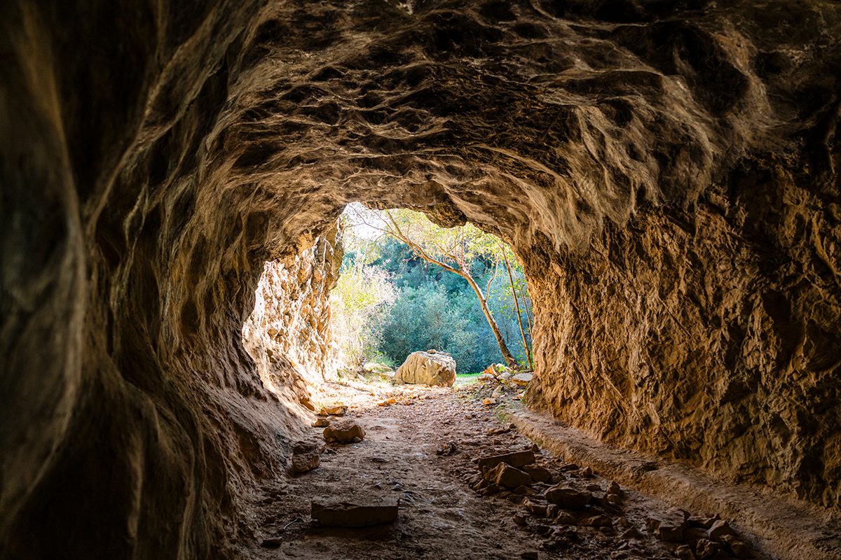 A photo taken from inside a cave rock tunnel