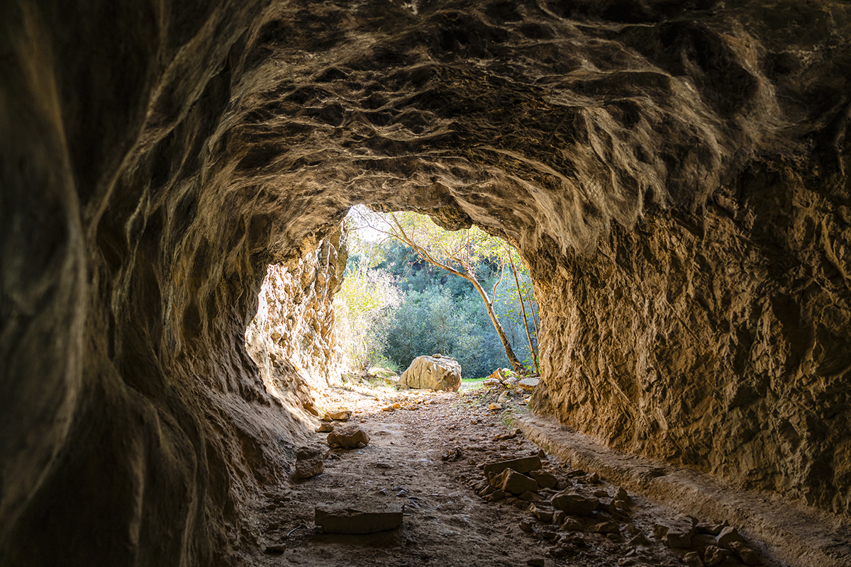 A photo taken from inside a cave rock tunnel