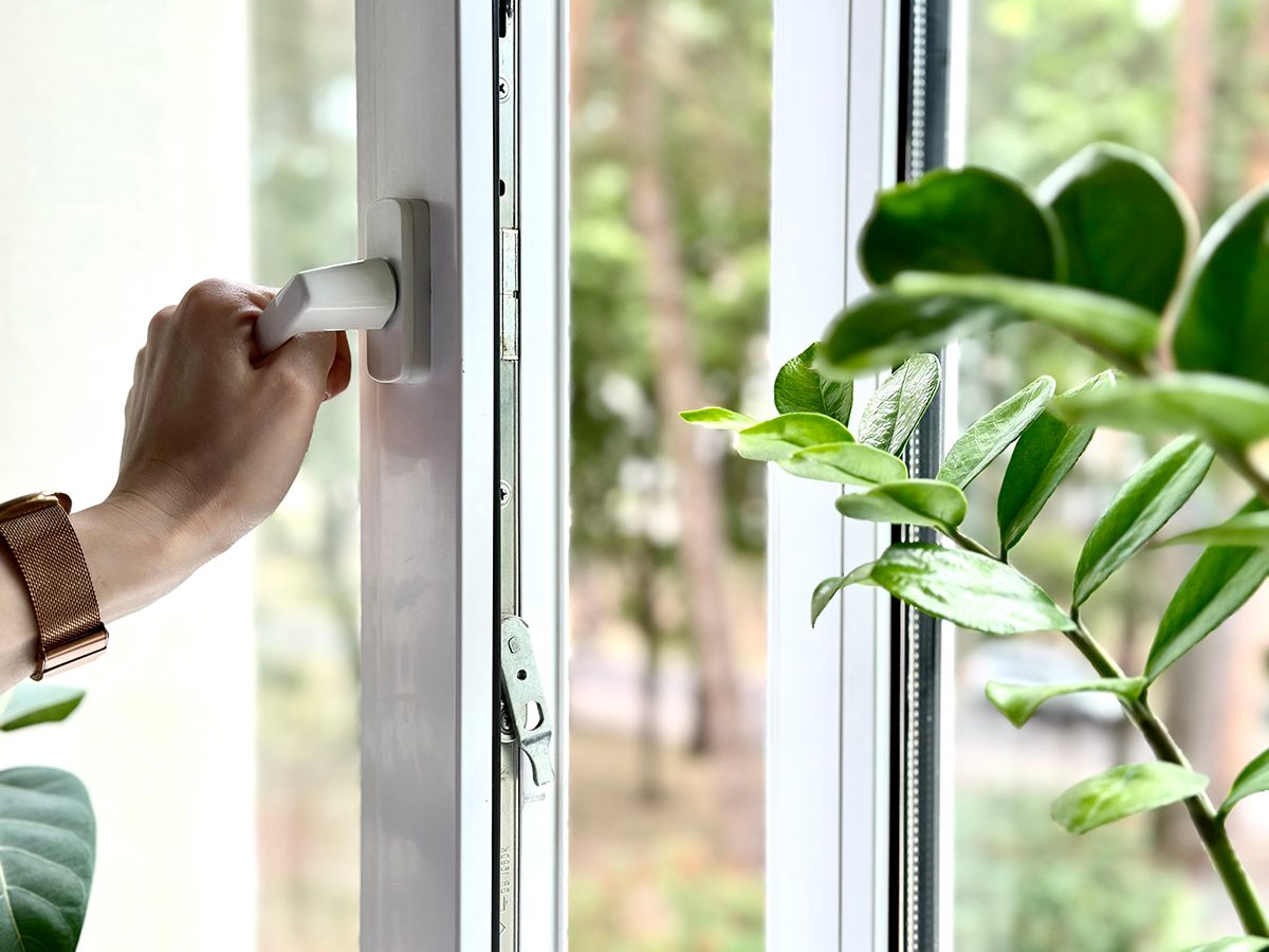 A woman's hand opening a window