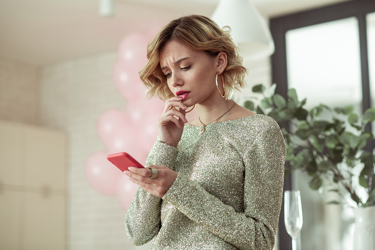 A stressed woman is looking at her phone