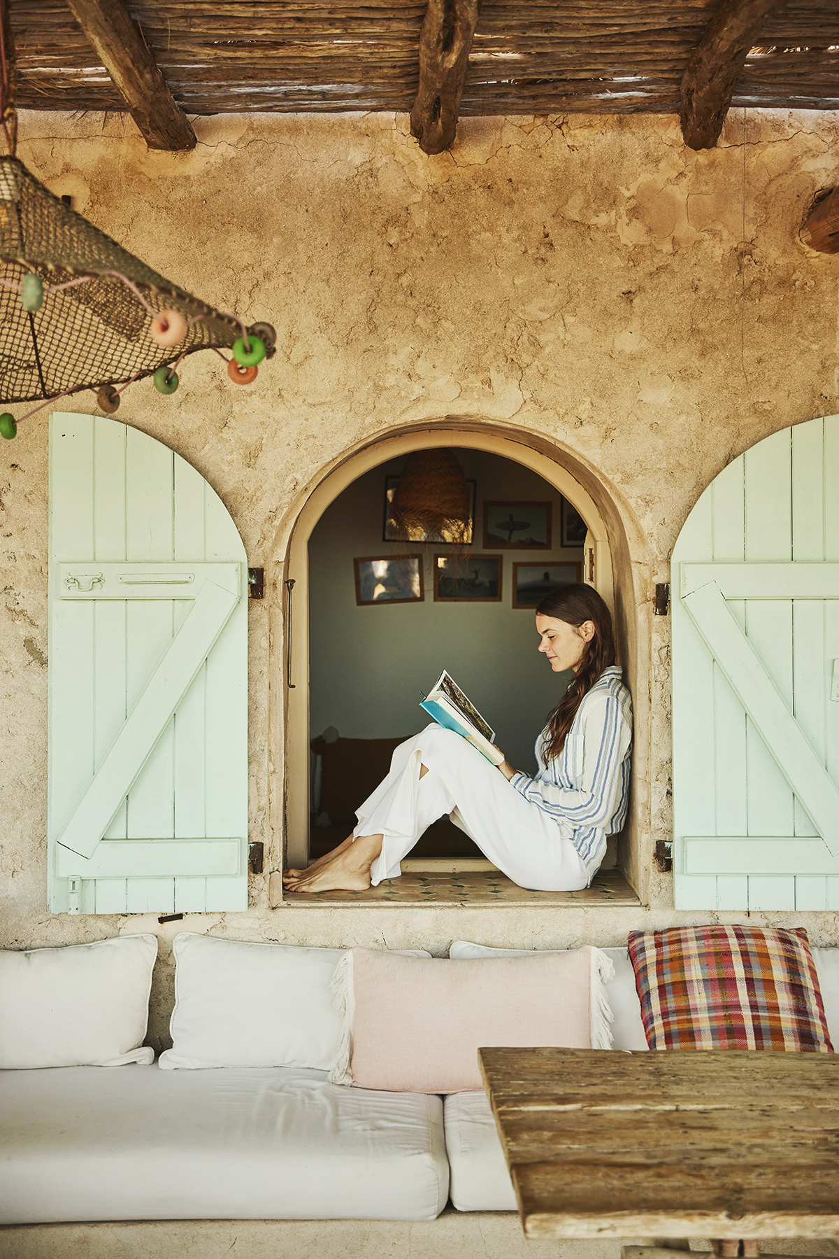 A woman sitting in the window of a villa reading