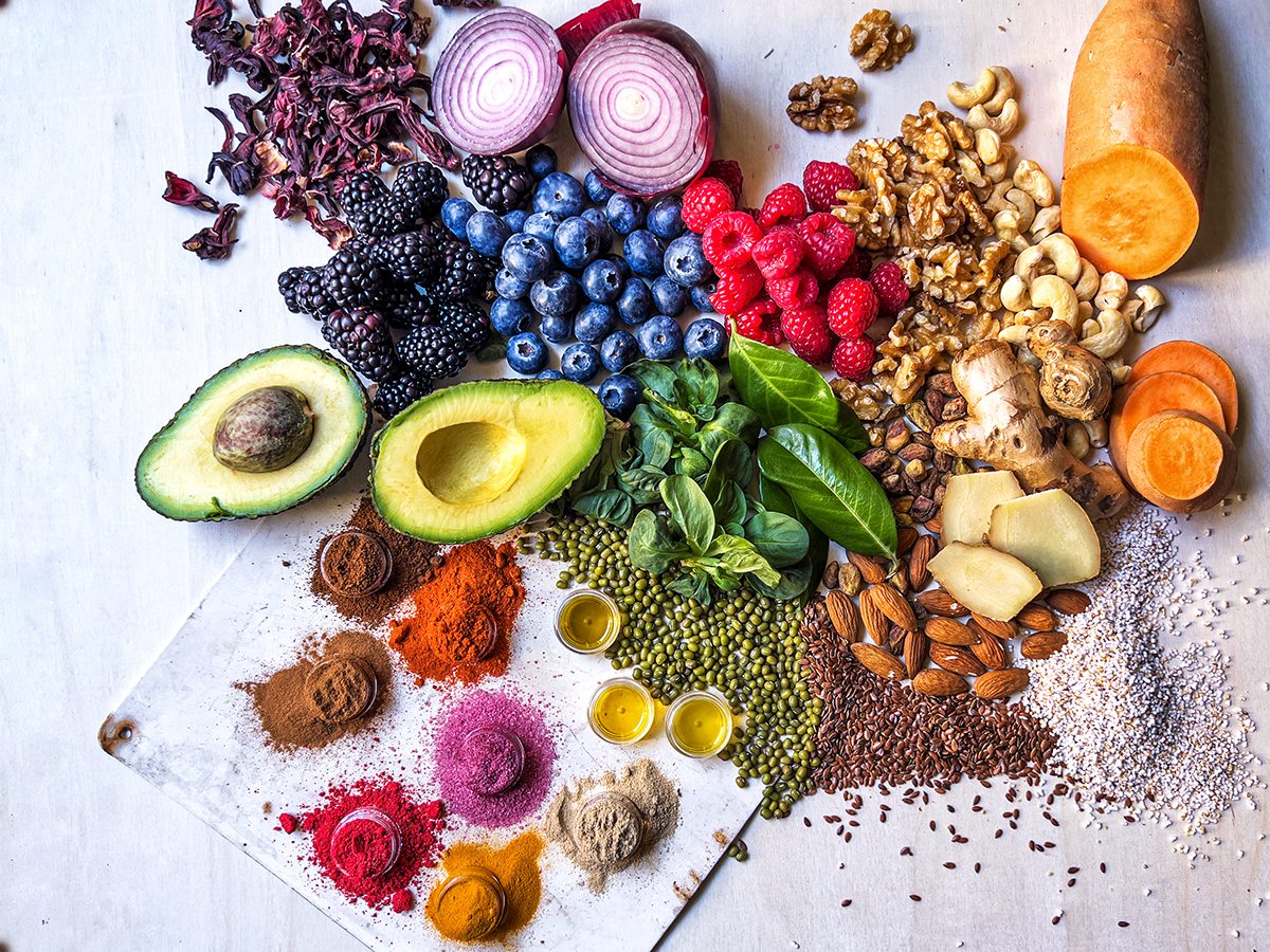 Fresh fruits and vegetables, legumes, nuts and spices on a wooden surface