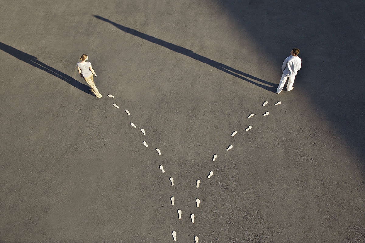 A man and woman walking away from each other, representing separation