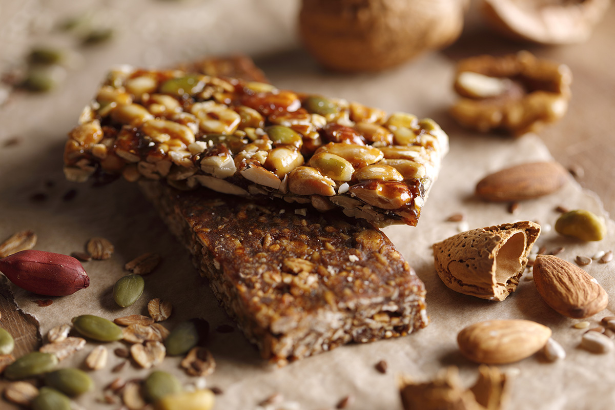 Two homemade protein bars containing oats, seeds and nuts
