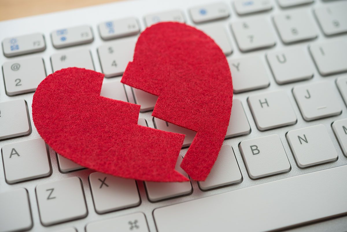 A red felt broken heart is on top of a keyboard