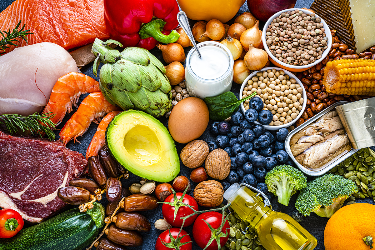 A range of healthy foods are shown, including meats, fish, fruits, vegetables, dairy products and legumes.
