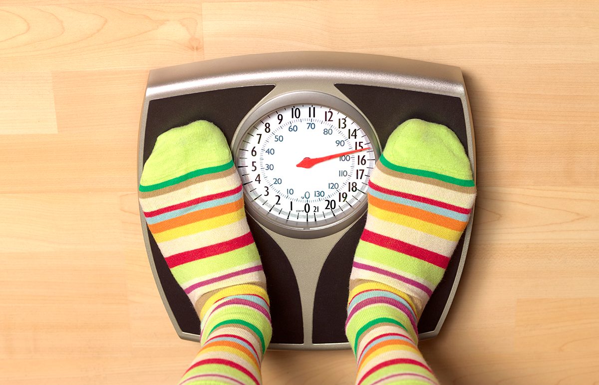 Feet wearing stripy socks standing on bathroom scales