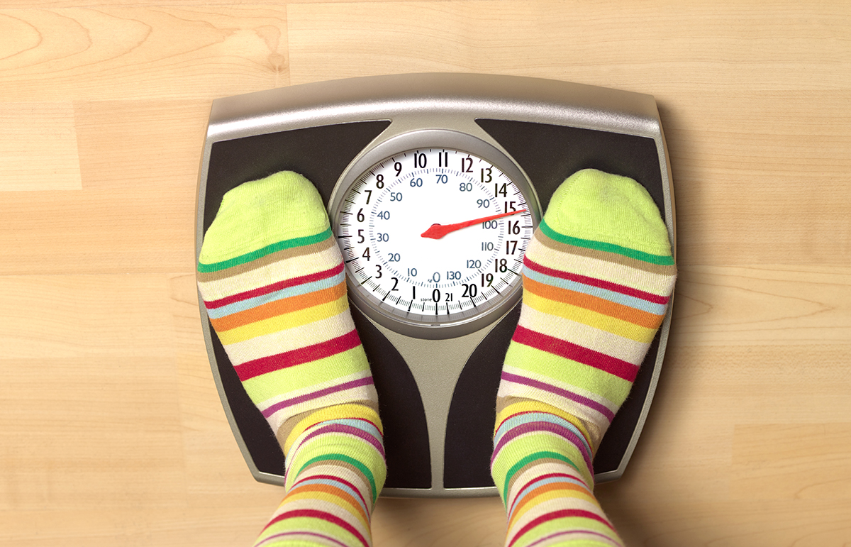 Feet wearing stripy socks standing on bathroom scales