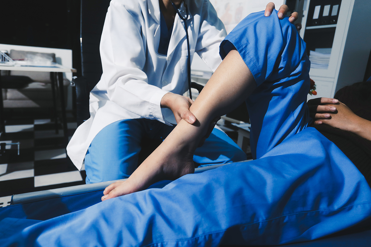 A doctor examining a patient's leg during a checkup.