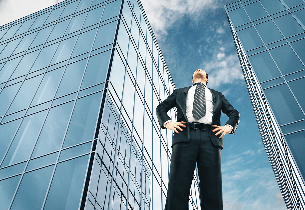 A businessman standing next to a skyscraper
