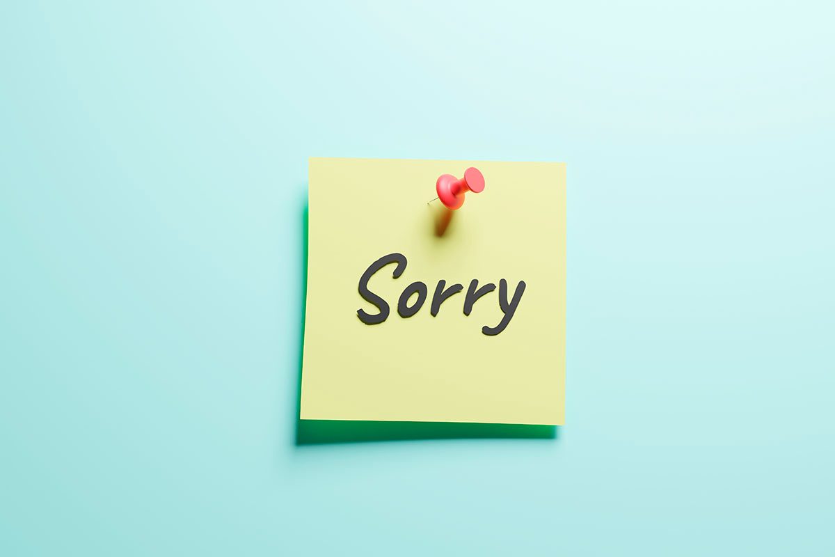 A yellow sticky note that reads "SORRY" on a blue background