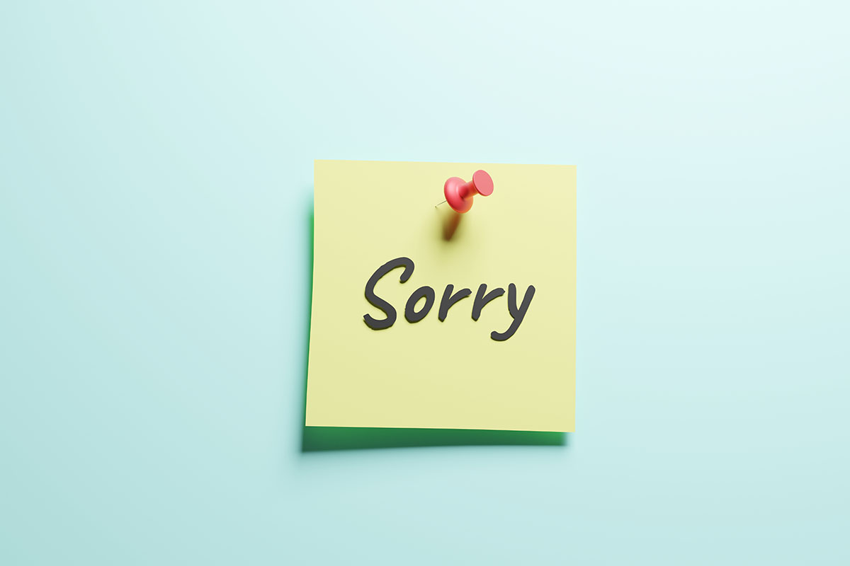 A yellow sticky note that reads "SORRY" on a blue background