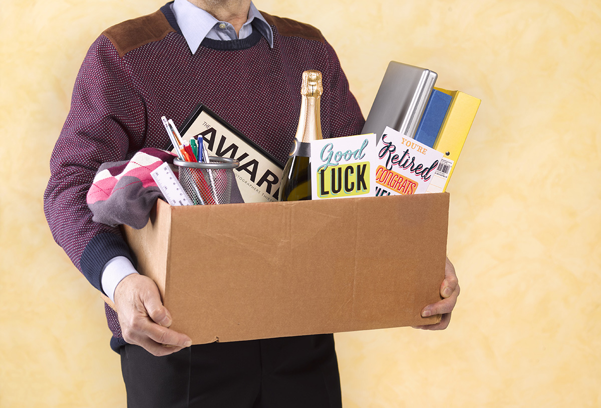 A man is carrying a cardboard box of belongings