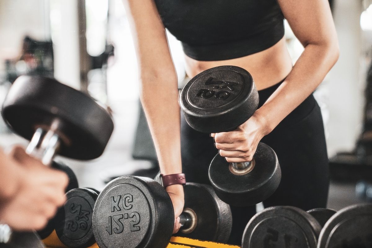 A woman picking up dumbbells