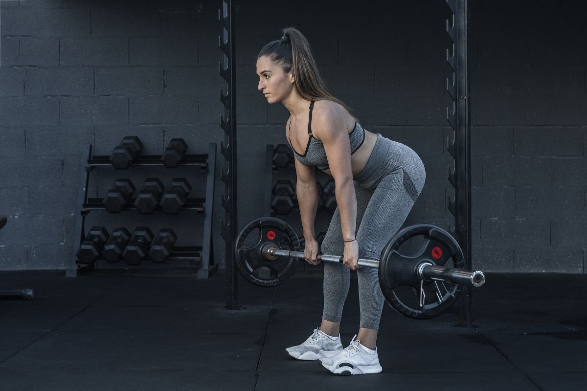 A woman performing a deadlift in a gym