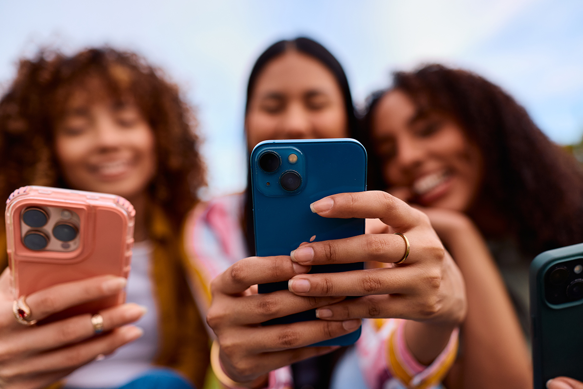 Three friends looking at mobile phones