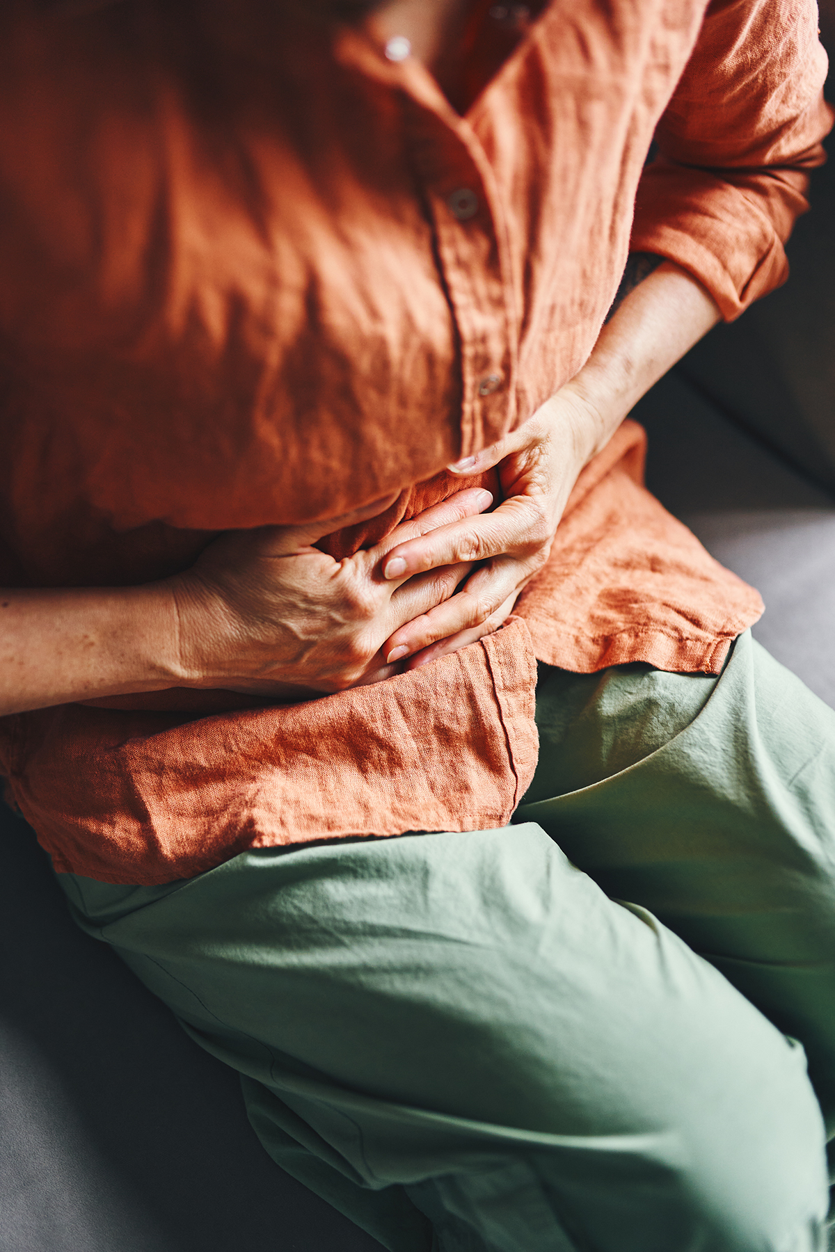 A cropped shot of a woman holding her stomach