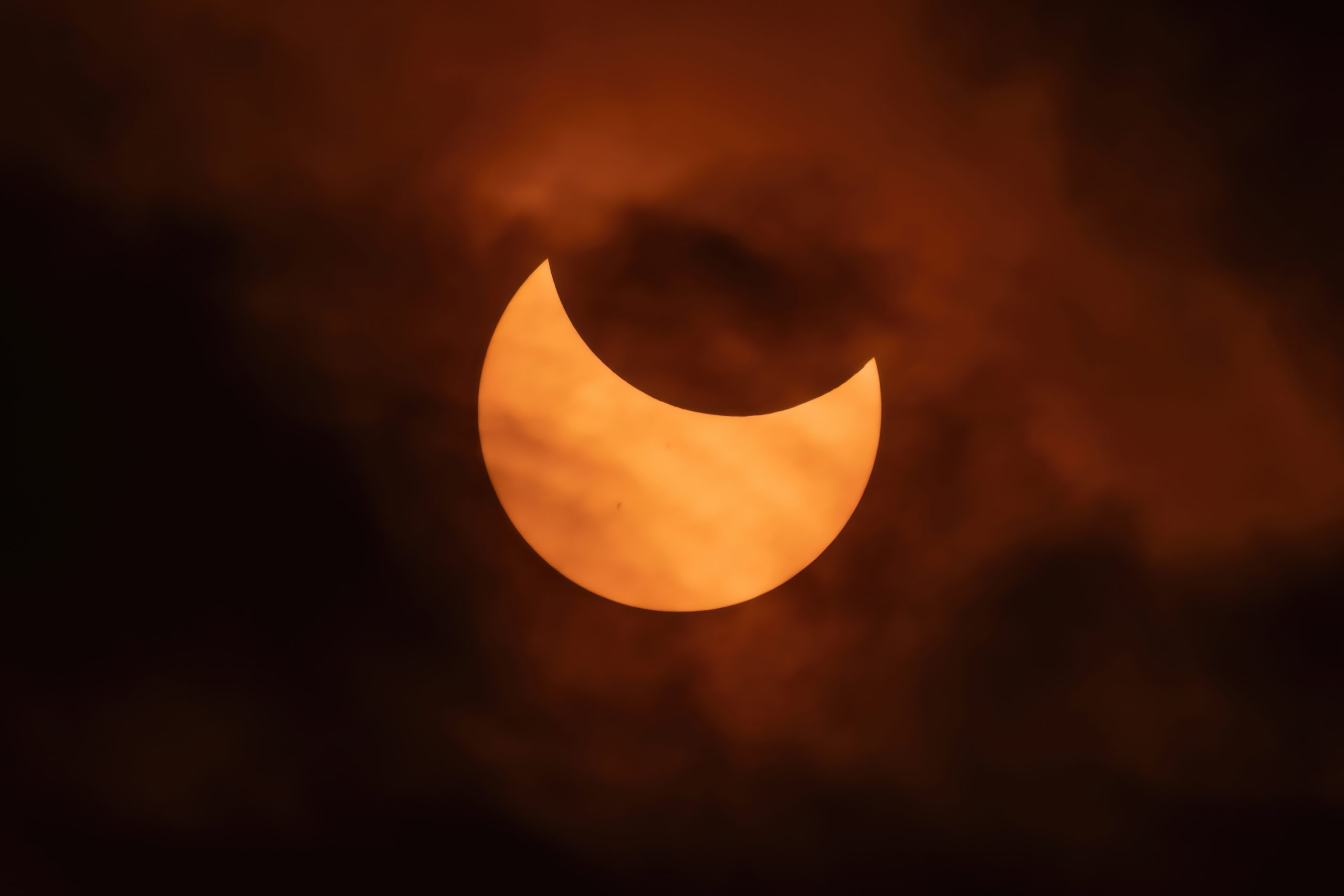 Partial solar eclipse on a cloudy night