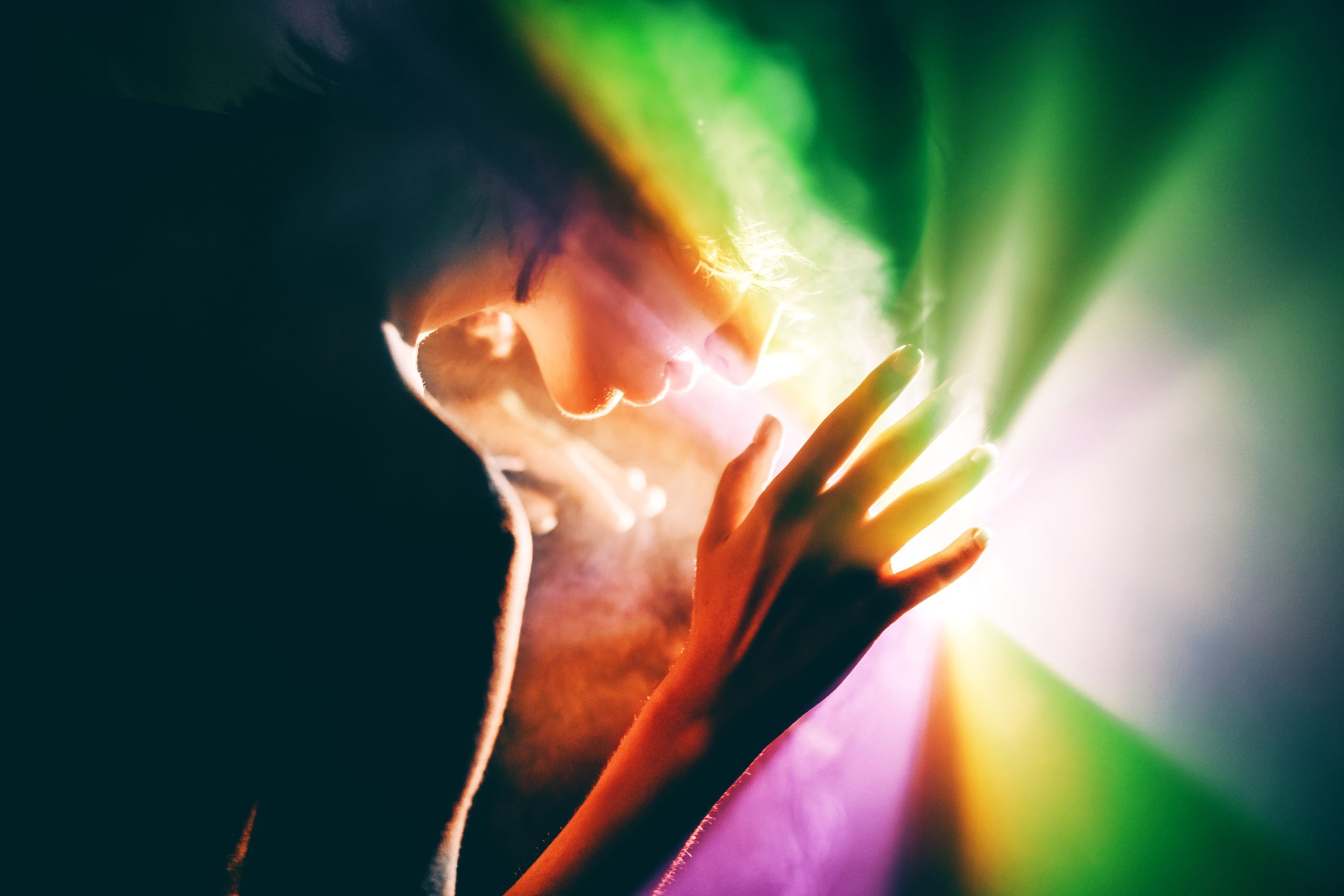 A woman touching colourful light