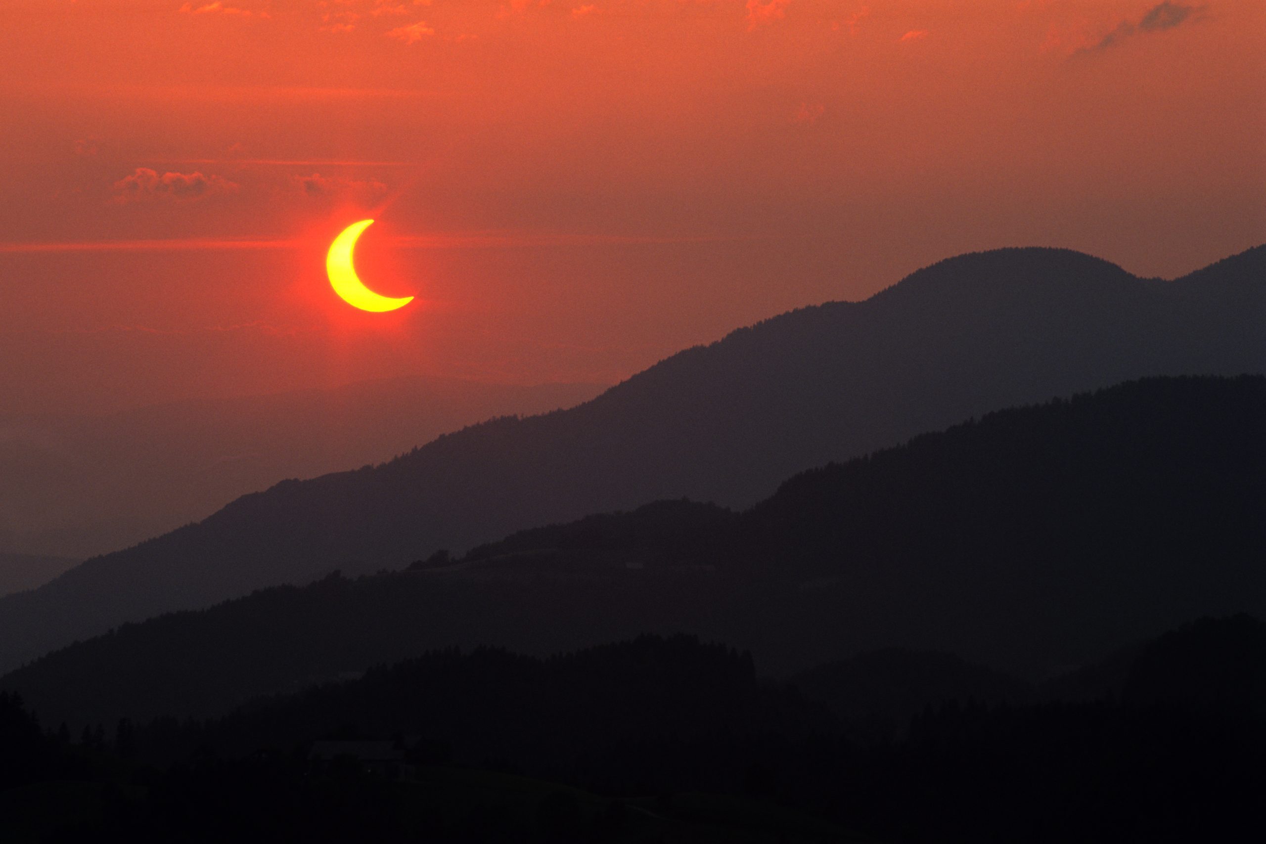 Partial solar eclipse over a landscape