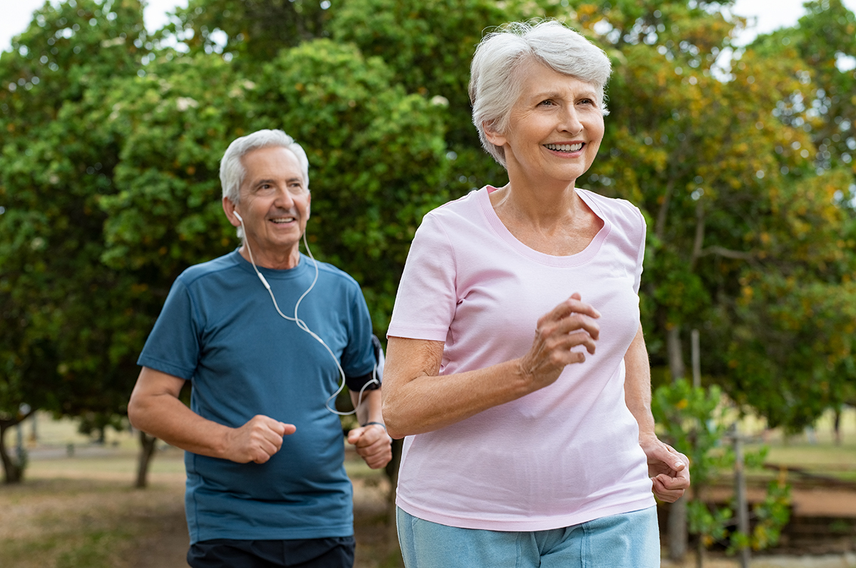 A senior couple jogging in a park