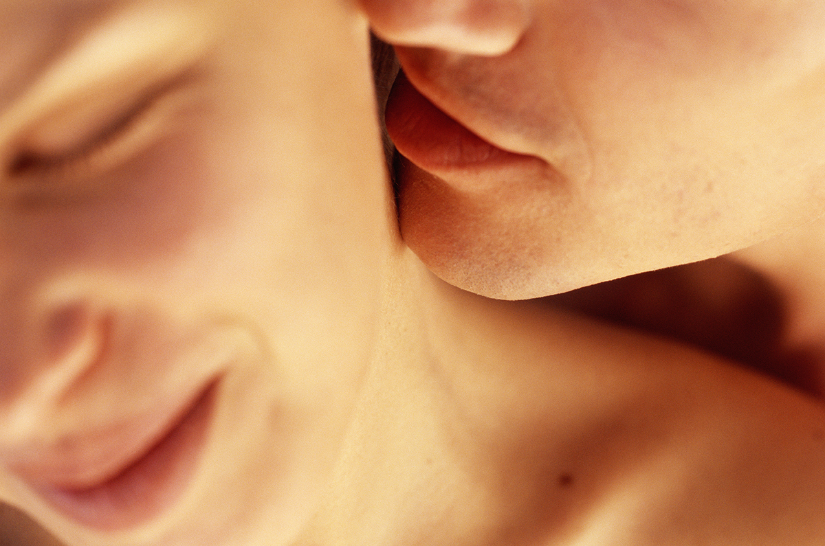 A close-up of a man caressing a woman's neck