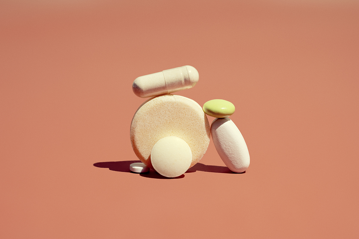 A range of tablets in different shapes and sizes are set in the centre of an orange background.