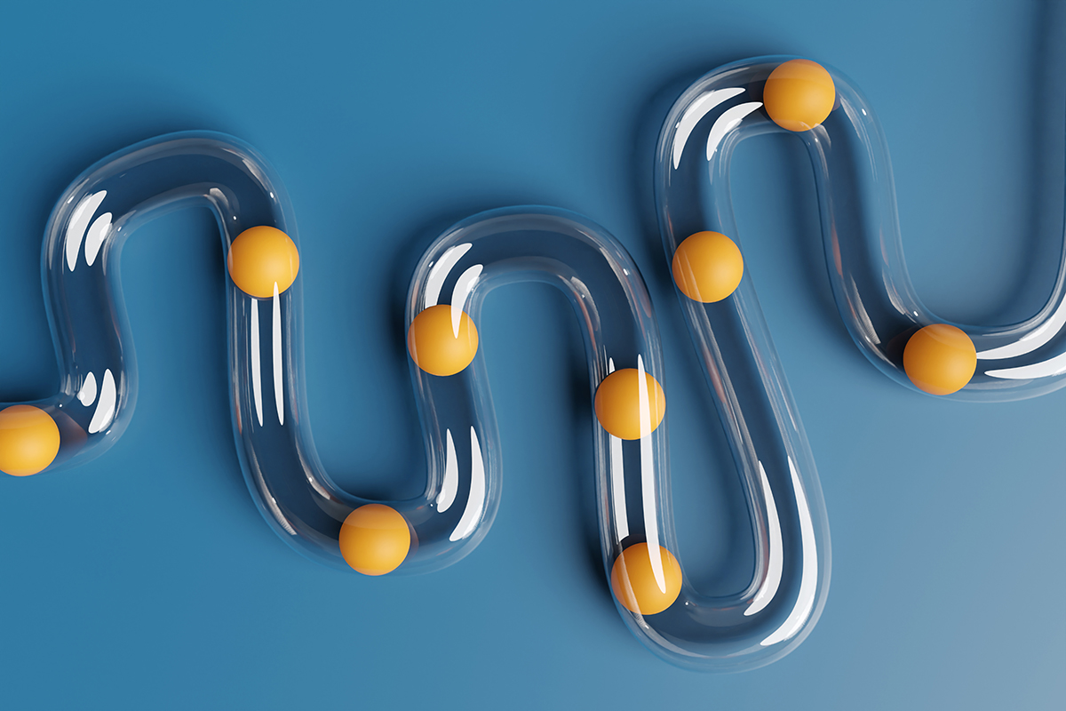 Orange balls are inside transparent plastic tubes on a blue background to represent digestion