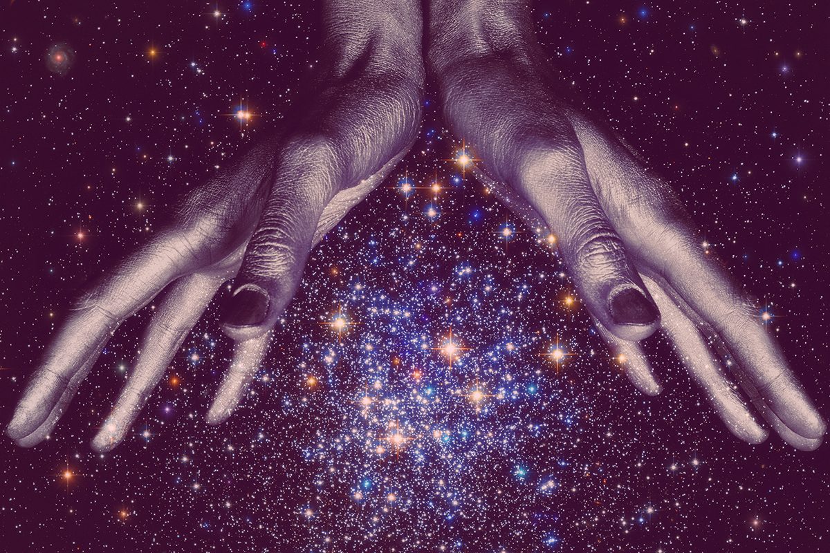 Human hands against a galaxy background