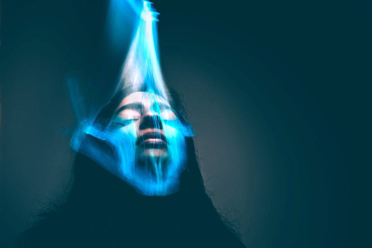 A woman's face being scanned by a futuristic identification device