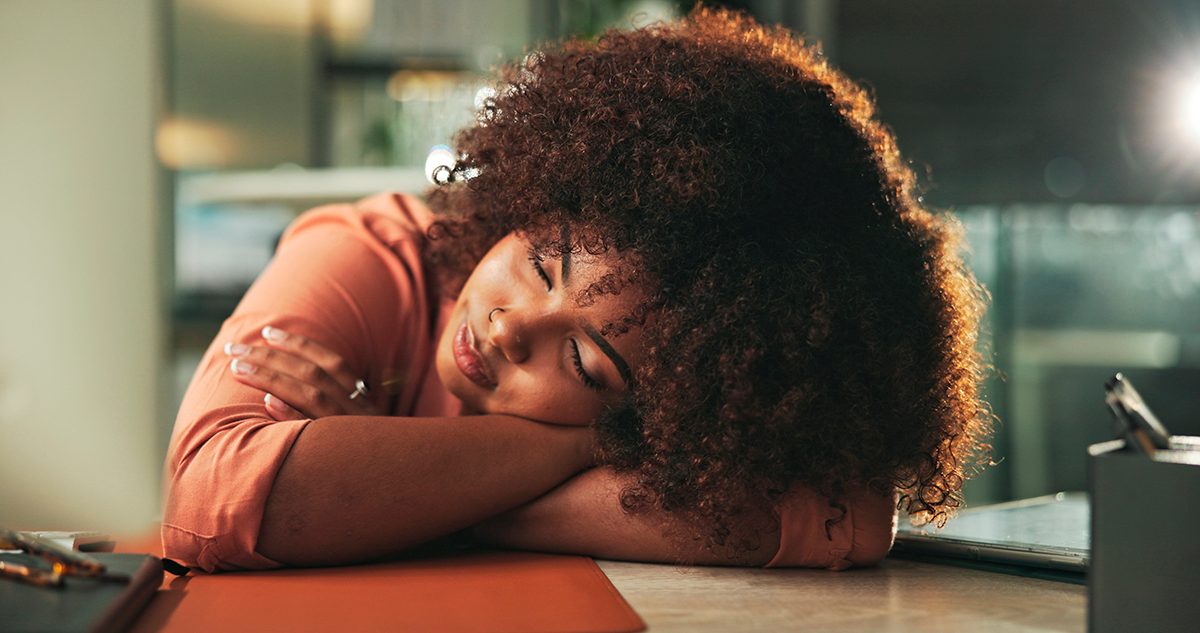 A woman sleeps at her desk