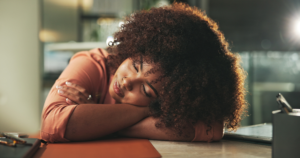 A woman sleeps at her desk
