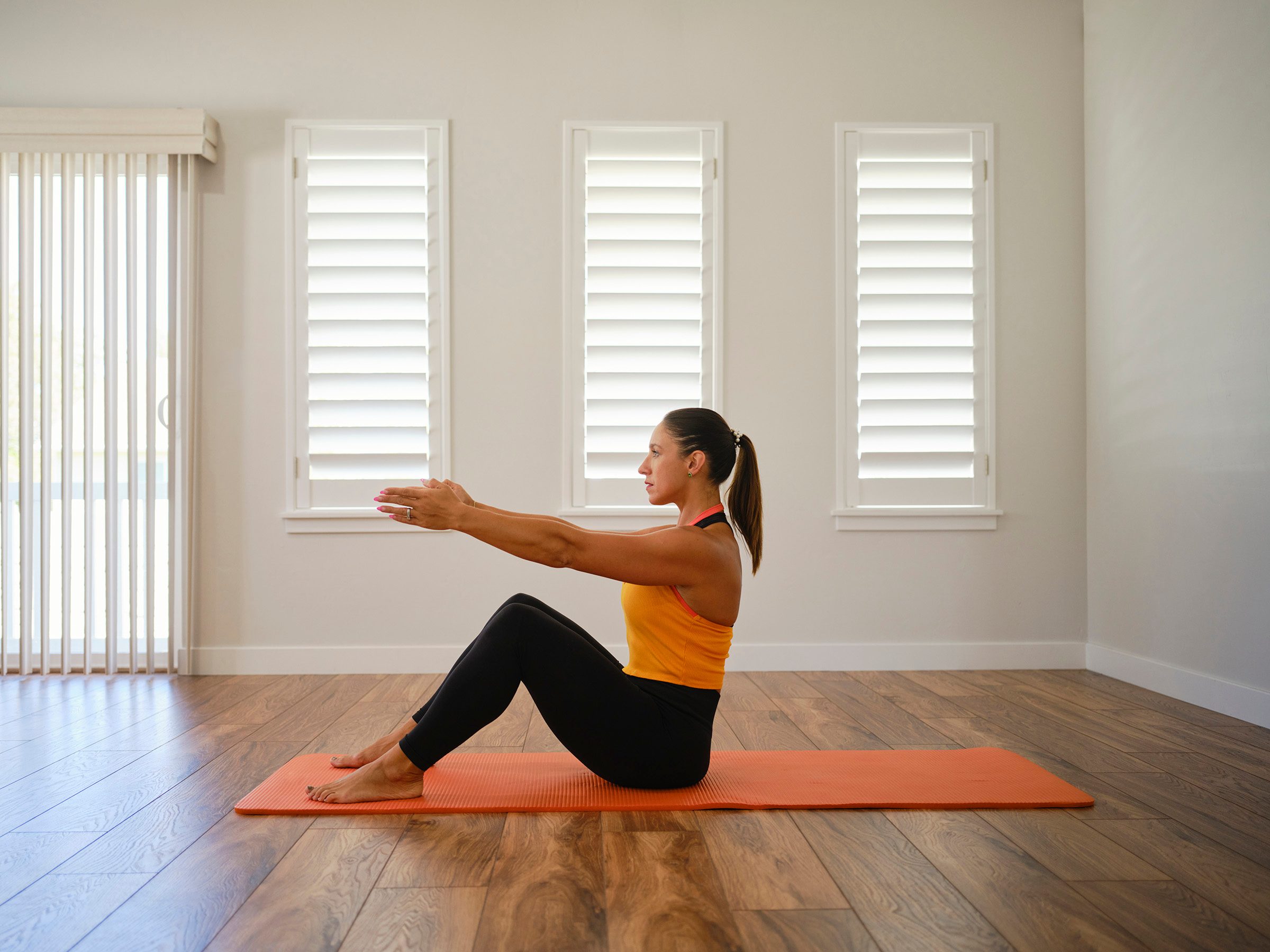 A young woman stretching and exercising in a home.