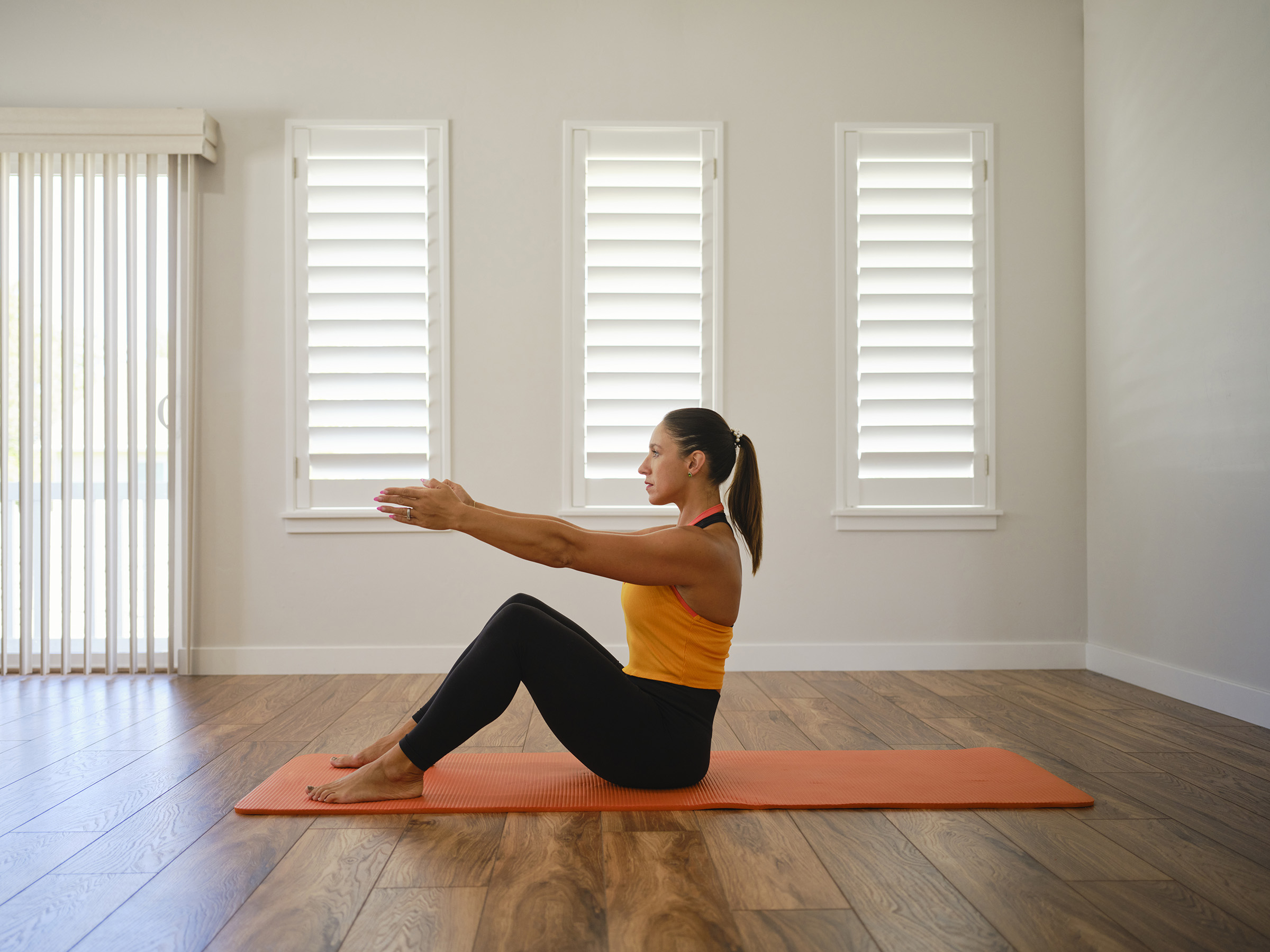 A young woman stretching and exercising in a home.