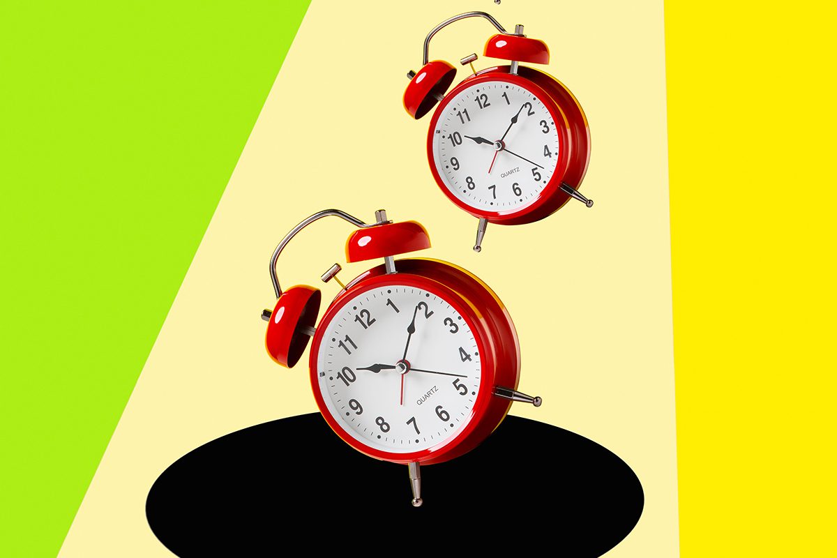 Five red alarm clocks fall into a black hole on a bright green and yellow background.