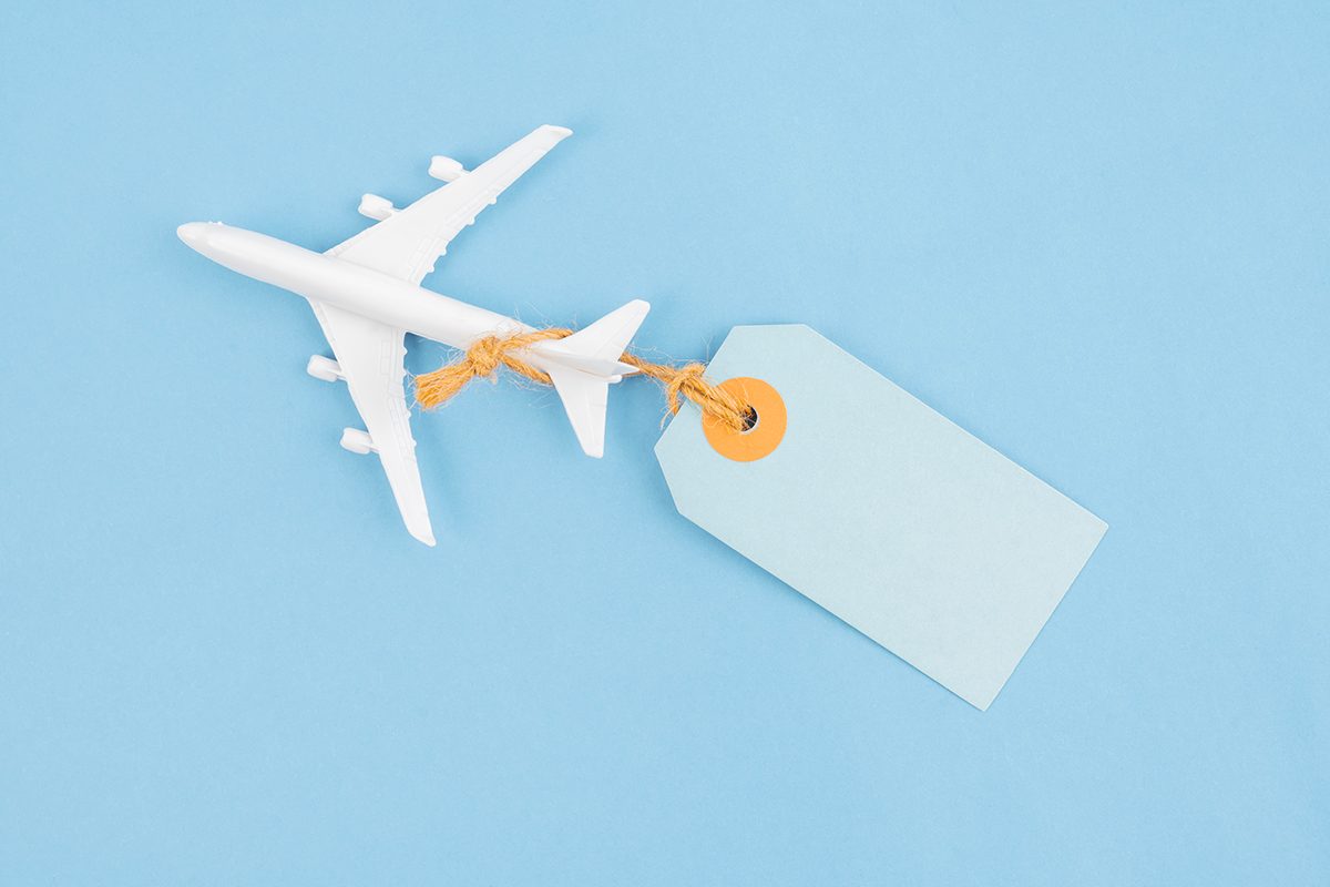 A model airplane with a blue price tag attached on a blue background