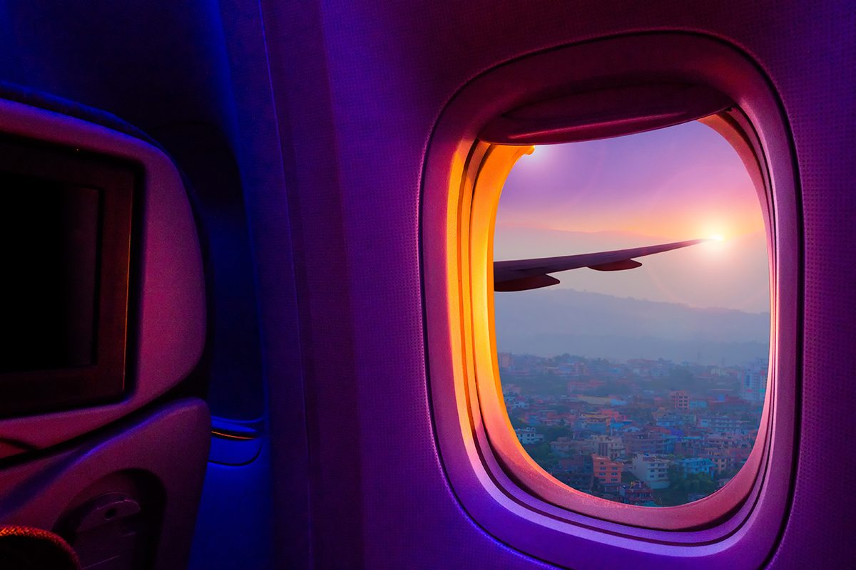 A view of a city at sunset from an airplane window