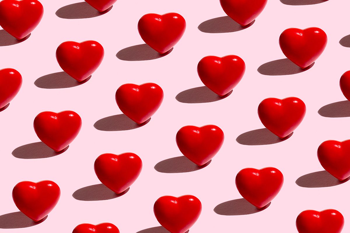 A pattern of 3D red love hearts on a pink background