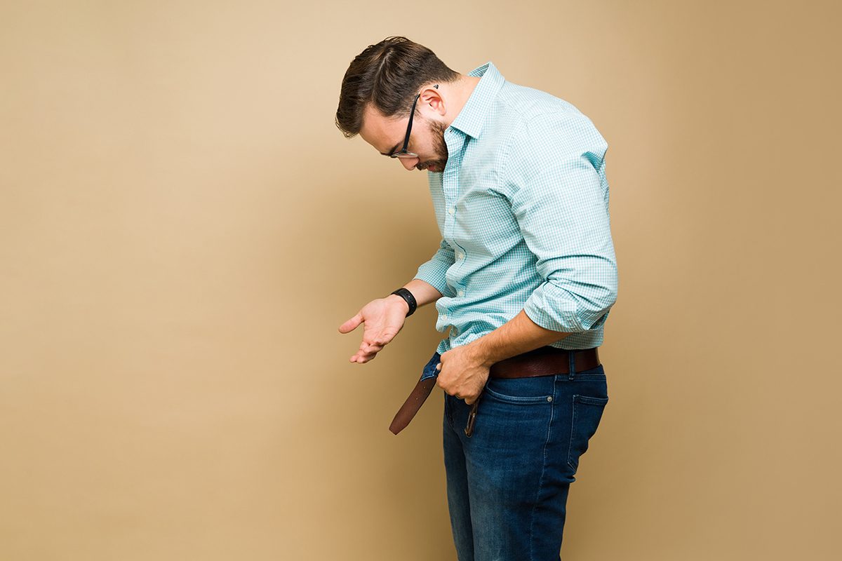 A stressed man looking at his groin under his jeans