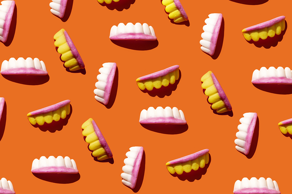 Teeth-shaped sweets on an orange background