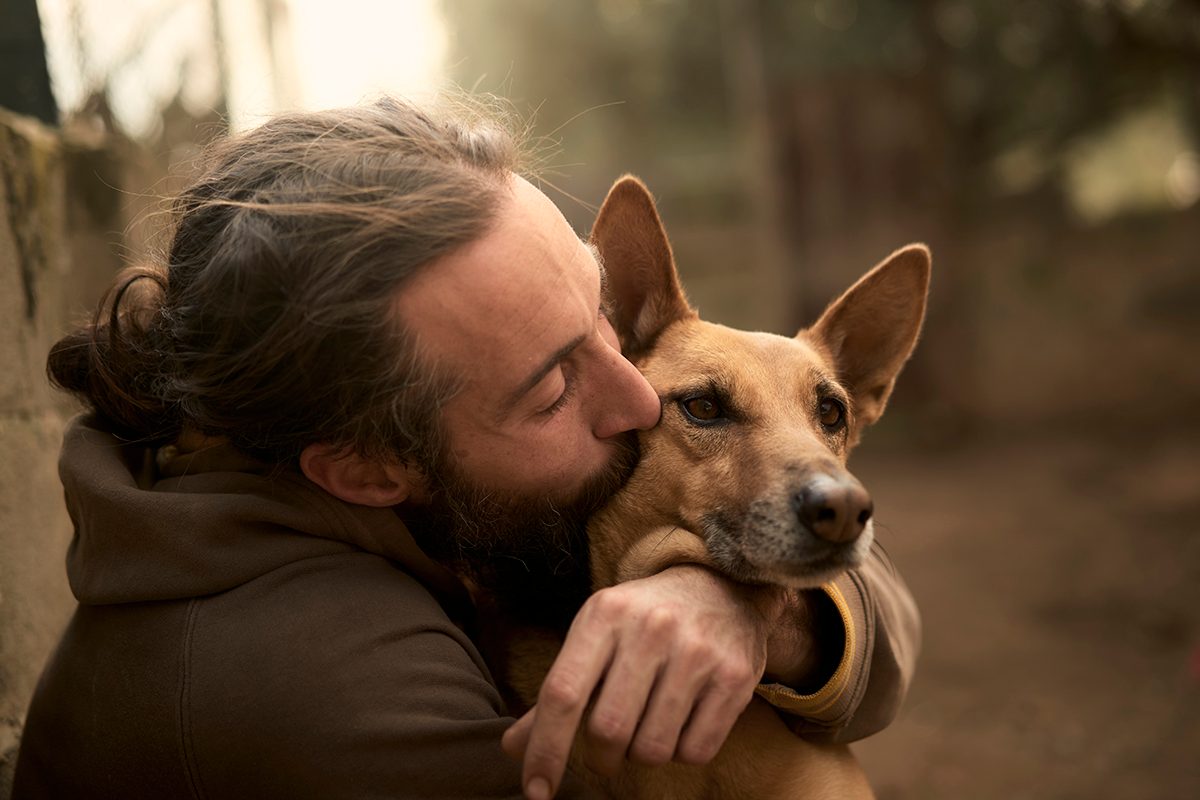 A man kissing his dog's face 