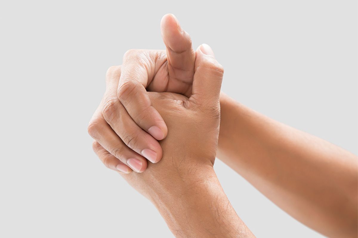 A man cracking his knuckles against a grey background