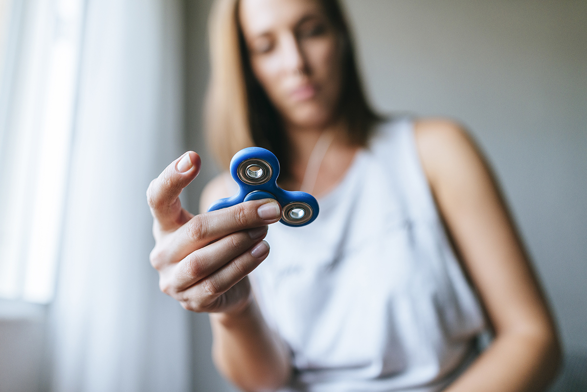 A woman playing with a fidget spinner