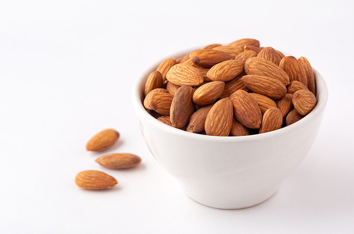 Almonds in a white bowl on a white background
