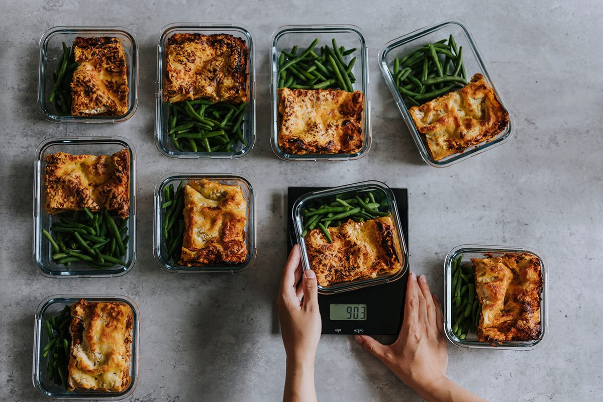 Overhead view of person weighing lunch boxes.