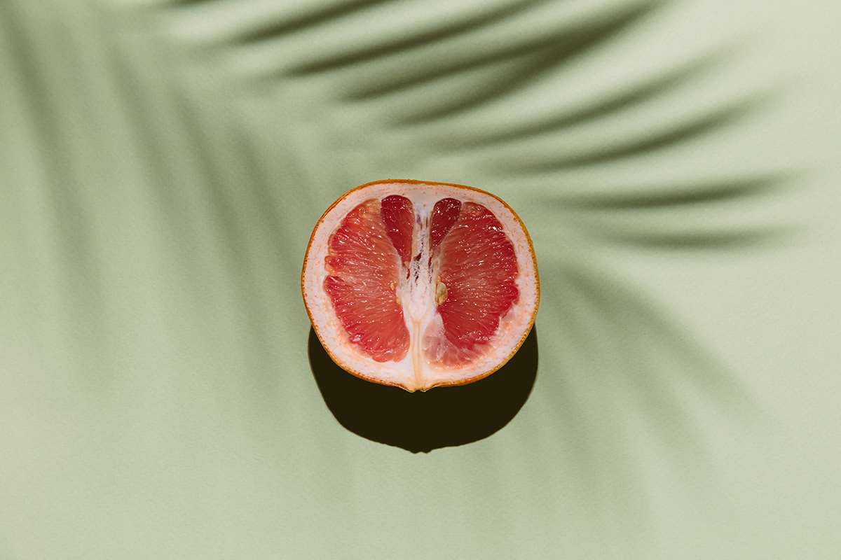 Half a grapefruit on a green background